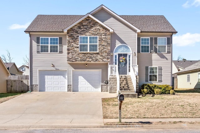 view of front facade with stone siding, a shingled roof, fence, and driveway