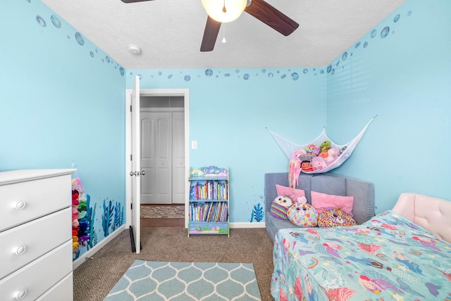 carpeted bedroom with ceiling fan, a textured ceiling, and baseboards