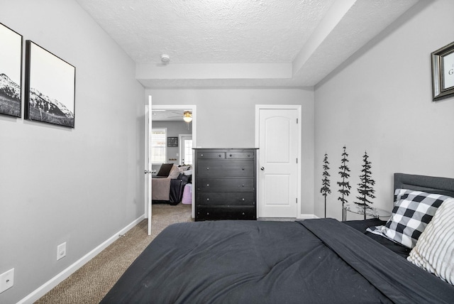 bedroom with carpet floors, a textured ceiling, and baseboards