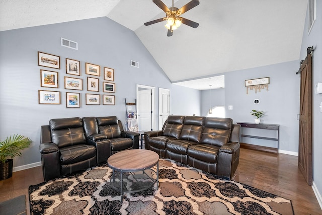 living area with wood finished floors, visible vents, ceiling fan, and a barn door