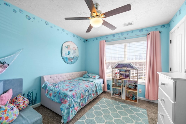 bedroom with carpet floors, visible vents, a textured ceiling, and baseboards