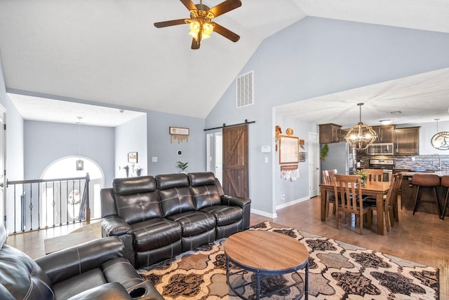 living room featuring a barn door, baseboards, visible vents, dark wood-type flooring, and ceiling fan with notable chandelier