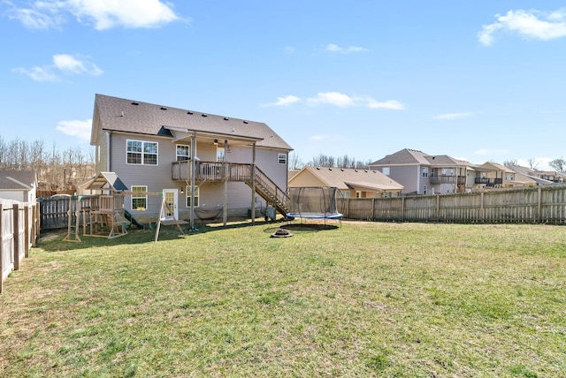 back of property featuring a fenced backyard, a trampoline, a playground, and a yard