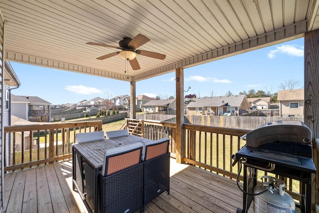 wooden terrace with ceiling fan, area for grilling, a fenced backyard, and a residential view