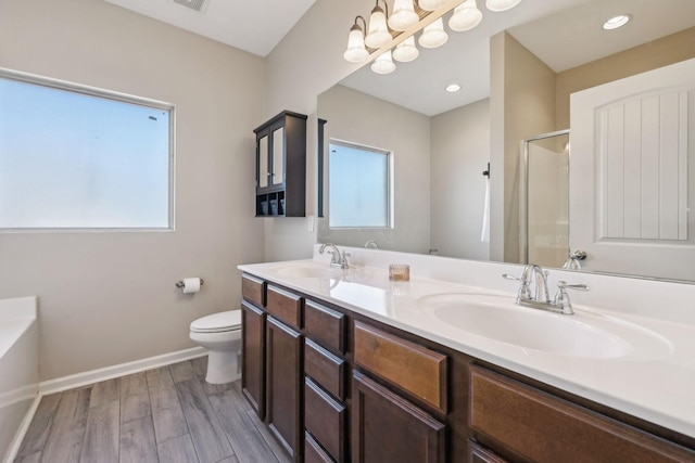 bathroom with toilet, baseboards, a sink, and wood finished floors