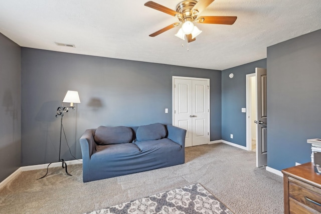 sitting room with a textured ceiling, ceiling fan, carpet, and baseboards