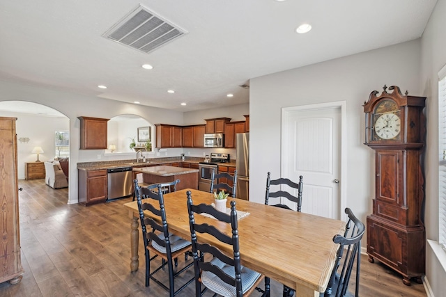 dining area with visible vents, arched walkways, dark wood-type flooring, and recessed lighting