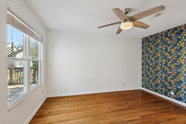 unfurnished room with visible vents, baseboards, and wood finished floors