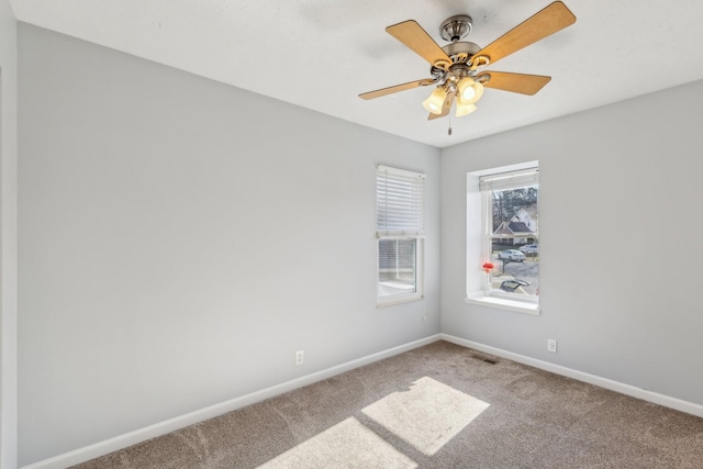 unfurnished room with a ceiling fan, carpet, and baseboards