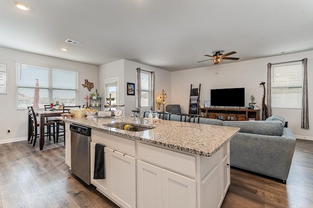 kitchen featuring dark wood-style floors, a kitchen island with sink, visible vents, and stainless steel dishwasher