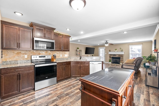 kitchen featuring decorative backsplash, stainless steel appliances, a sink, and wood finished floors