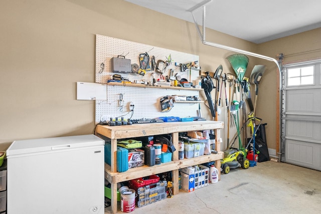 garage featuring a workshop area and white refrigerator