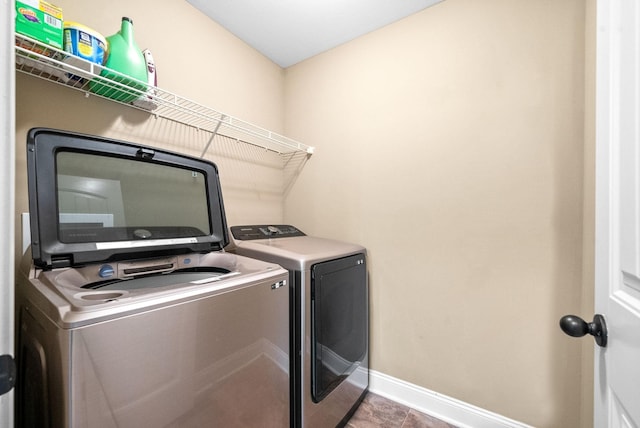 clothes washing area featuring laundry area, independent washer and dryer, and baseboards