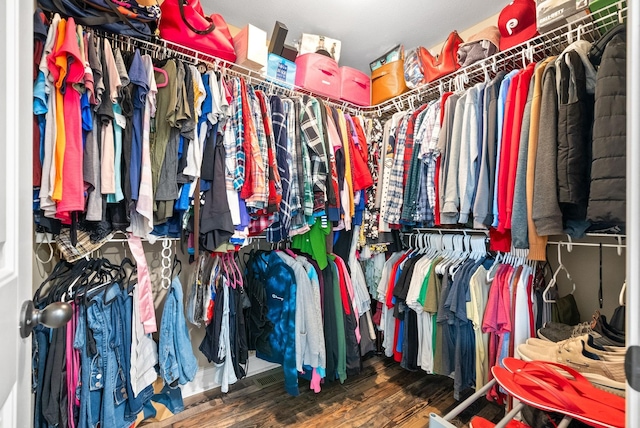 walk in closet with wood finished floors