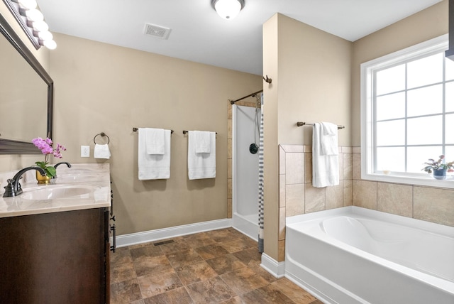 bathroom featuring visible vents, a sink, baseboards, and a bath