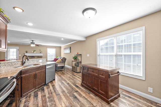 kitchen with appliances with stainless steel finishes, dark wood-type flooring, a sink, and a wealth of natural light