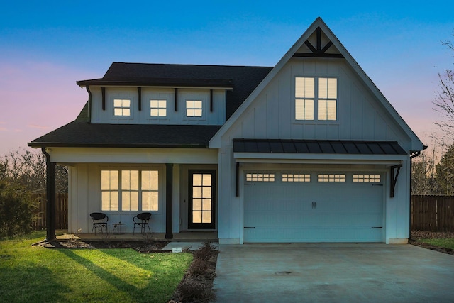 view of front of house featuring an attached garage, board and batten siding, driveway, and fence