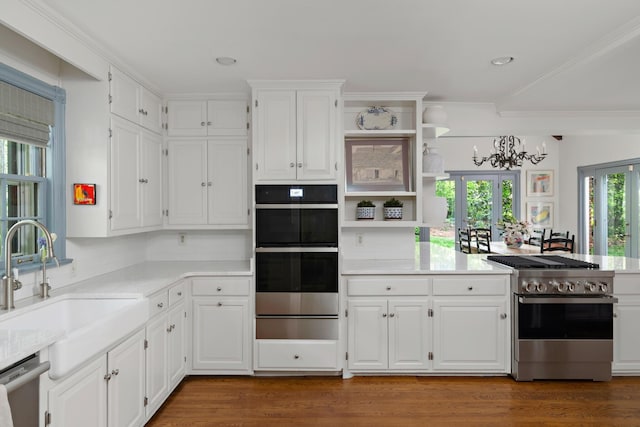 kitchen with appliances with stainless steel finishes, white cabinetry, open shelves, a sink, and a warming drawer