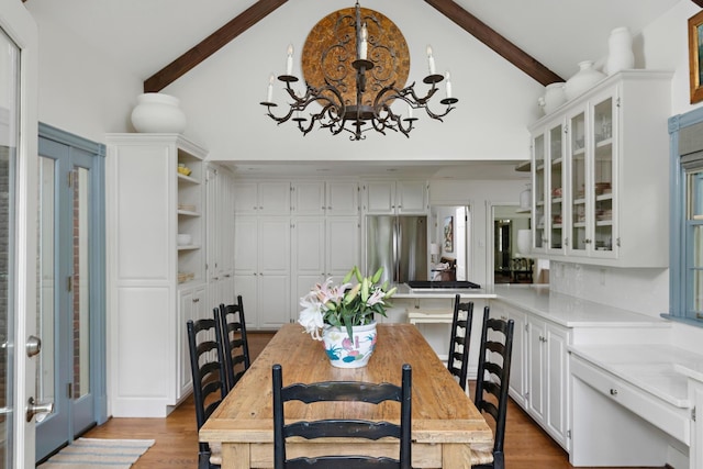 dining space with beamed ceiling, french doors, light wood-type flooring, high vaulted ceiling, and a notable chandelier