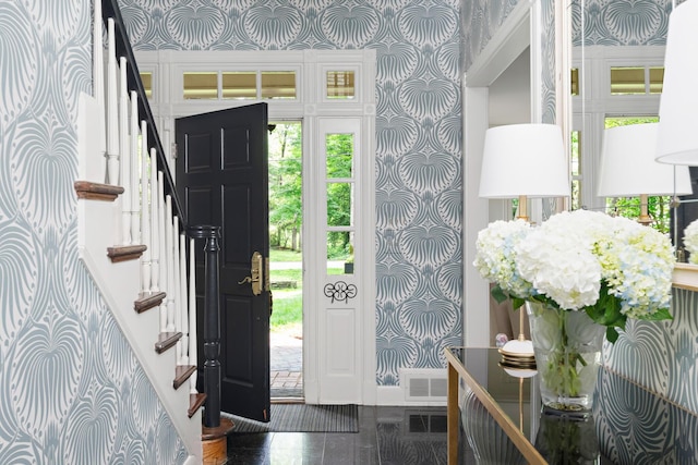 foyer entrance featuring stairs, visible vents, granite finish floor, and wallpapered walls