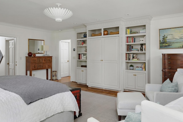 bedroom with ornamental molding and wood finished floors