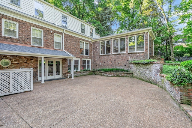 rear view of house featuring french doors, a patio area, and brick siding