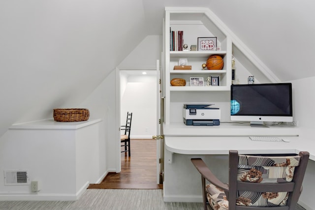 office area with baseboards, visible vents, vaulted ceiling, and wood finished floors