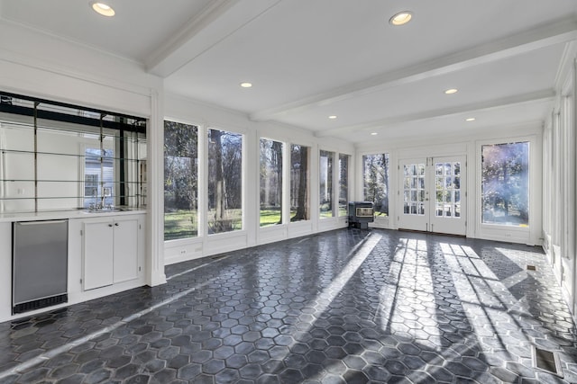 interior space featuring a healthy amount of sunlight, a sink, beam ceiling, and french doors