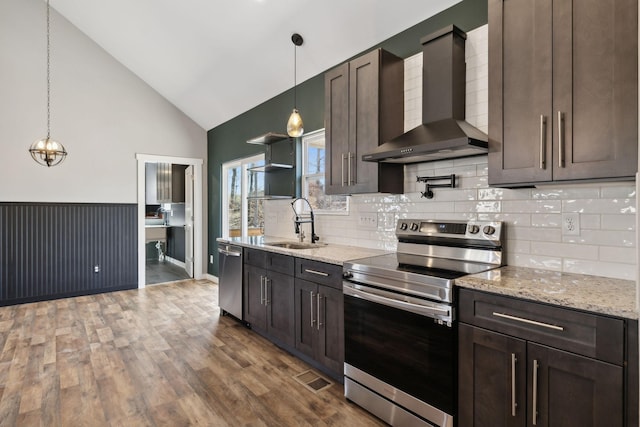 kitchen featuring visible vents, wall chimney exhaust hood, appliances with stainless steel finishes, dark wood-type flooring, and a sink