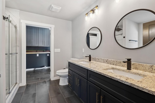 full bath featuring a sink, a shower stall, toilet, and double vanity