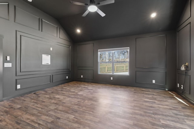 spare room featuring a ceiling fan, wood finished floors, vaulted ceiling, a decorative wall, and recessed lighting