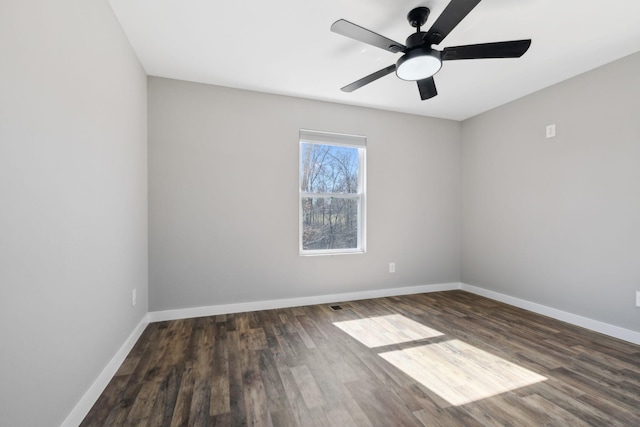 empty room featuring a ceiling fan, baseboards, and wood finished floors