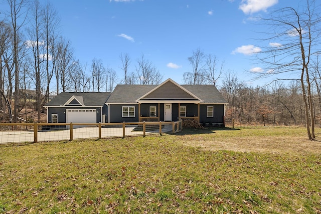 view of front of house featuring a garage, a front lawn, and a fenced front yard