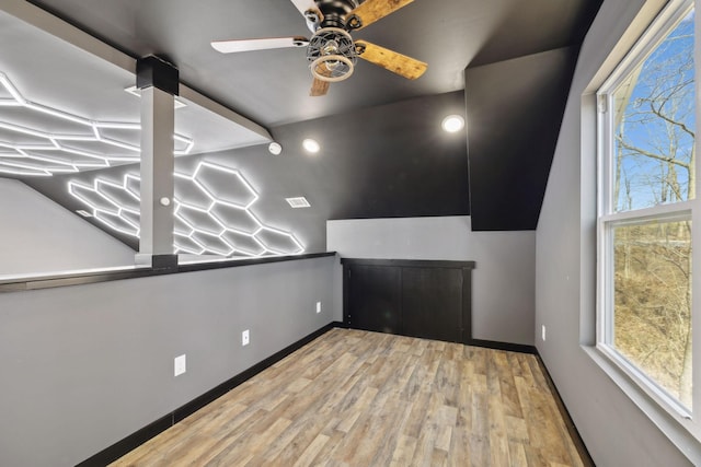 interior space with visible vents, ceiling fan, baseboards, and wood finished floors