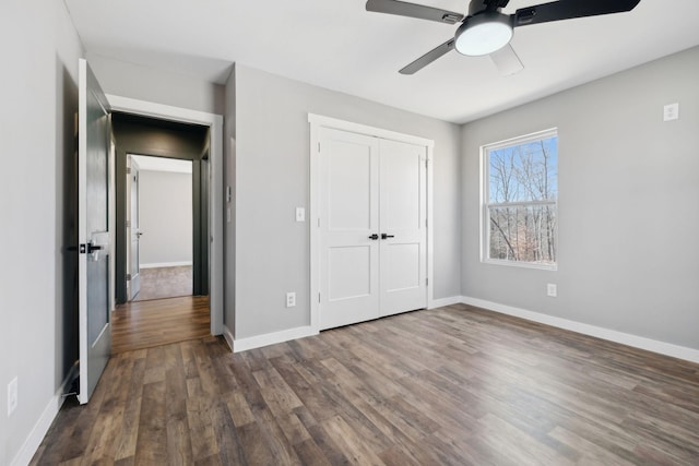 unfurnished bedroom with a ceiling fan, a closet, baseboards, and wood finished floors