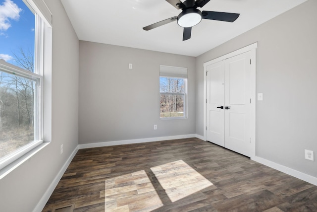 unfurnished bedroom with a closet, baseboards, and wood finished floors