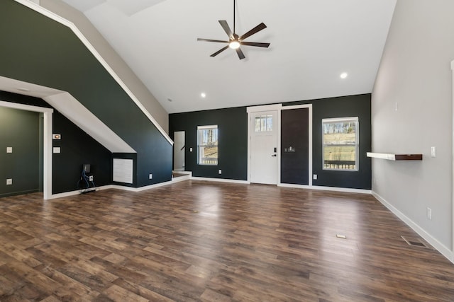 unfurnished living room featuring dark wood-type flooring, a wealth of natural light, and a ceiling fan