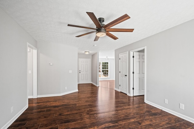 spare room with ceiling fan, a textured ceiling, baseboards, and wood finished floors