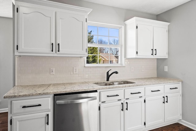 kitchen with a sink, decorative backsplash, white cabinets, and stainless steel dishwasher