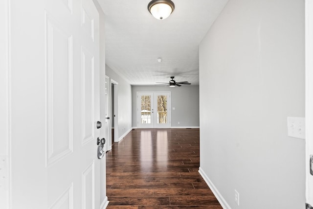 hallway with dark wood-style floors, baseboards, and french doors