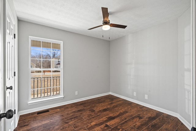 spare room with baseboards, visible vents, a ceiling fan, dark wood-style flooring, and a textured ceiling