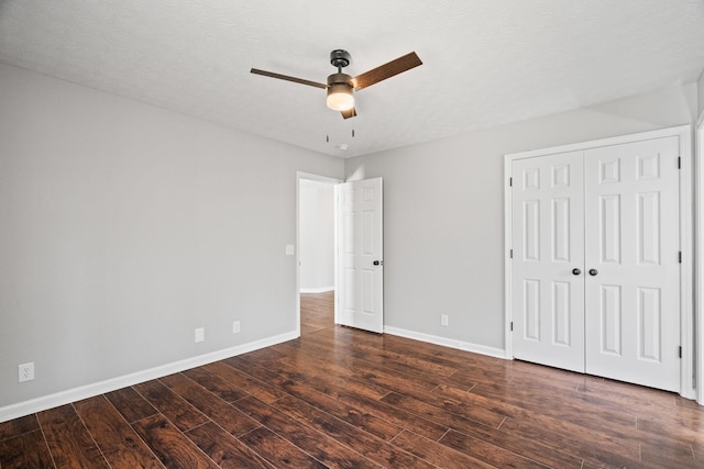 unfurnished bedroom featuring a closet, dark wood-style flooring, ceiling fan, and baseboards