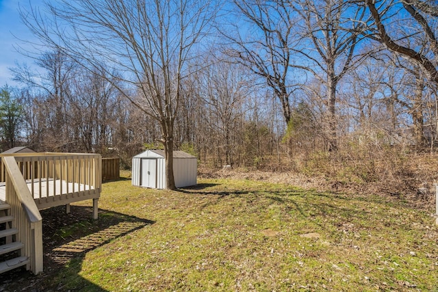 view of yard with an outbuilding, a wooden deck, and a shed