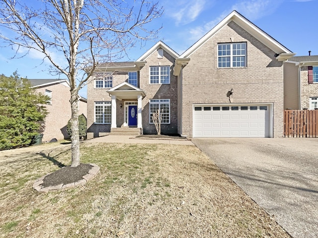 traditional-style house with an attached garage, fence, concrete driveway, and brick siding