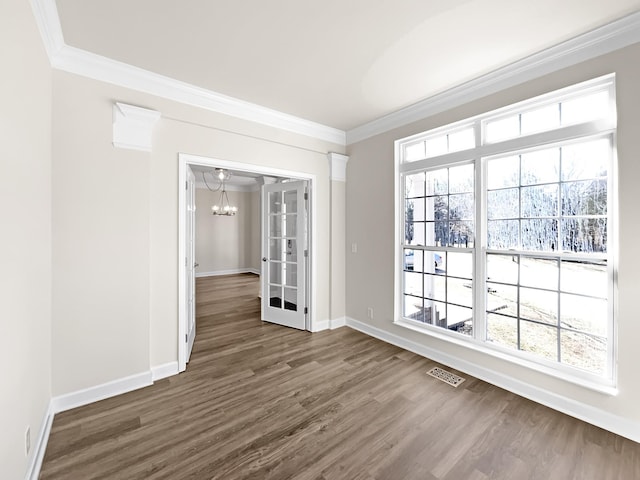 empty room featuring baseboards, visible vents, dark wood-style flooring, and crown molding