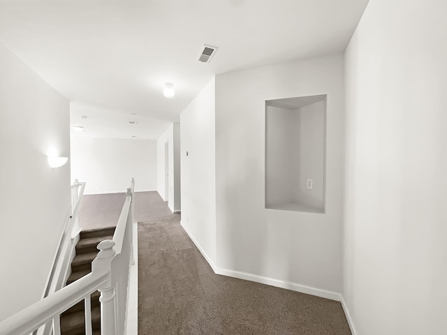 corridor with carpet floors, an upstairs landing, visible vents, and baseboards