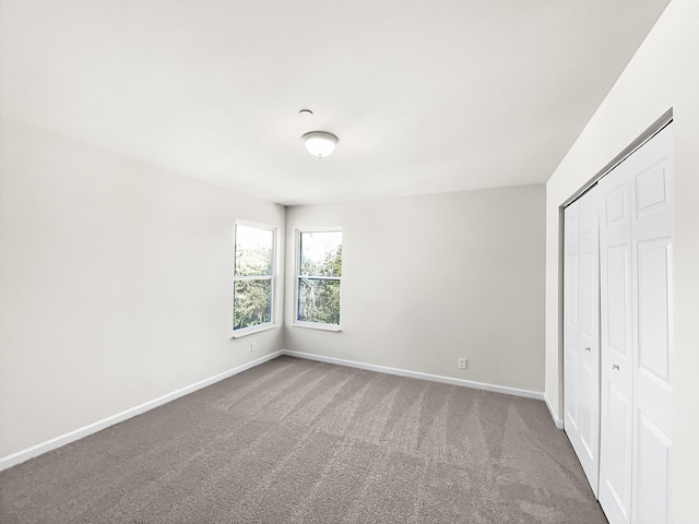 unfurnished bedroom featuring a closet, carpet flooring, and baseboards