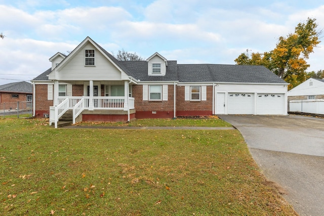 view of front of home with aphalt driveway, covered porch, a garage, brick siding, and a front yard