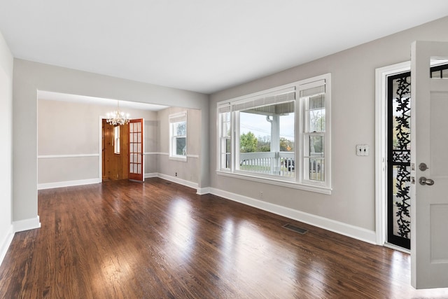 foyer featuring an inviting chandelier, baseboards, and dark wood-style flooring