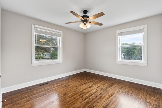 empty room featuring a healthy amount of sunlight, visible vents, and baseboards